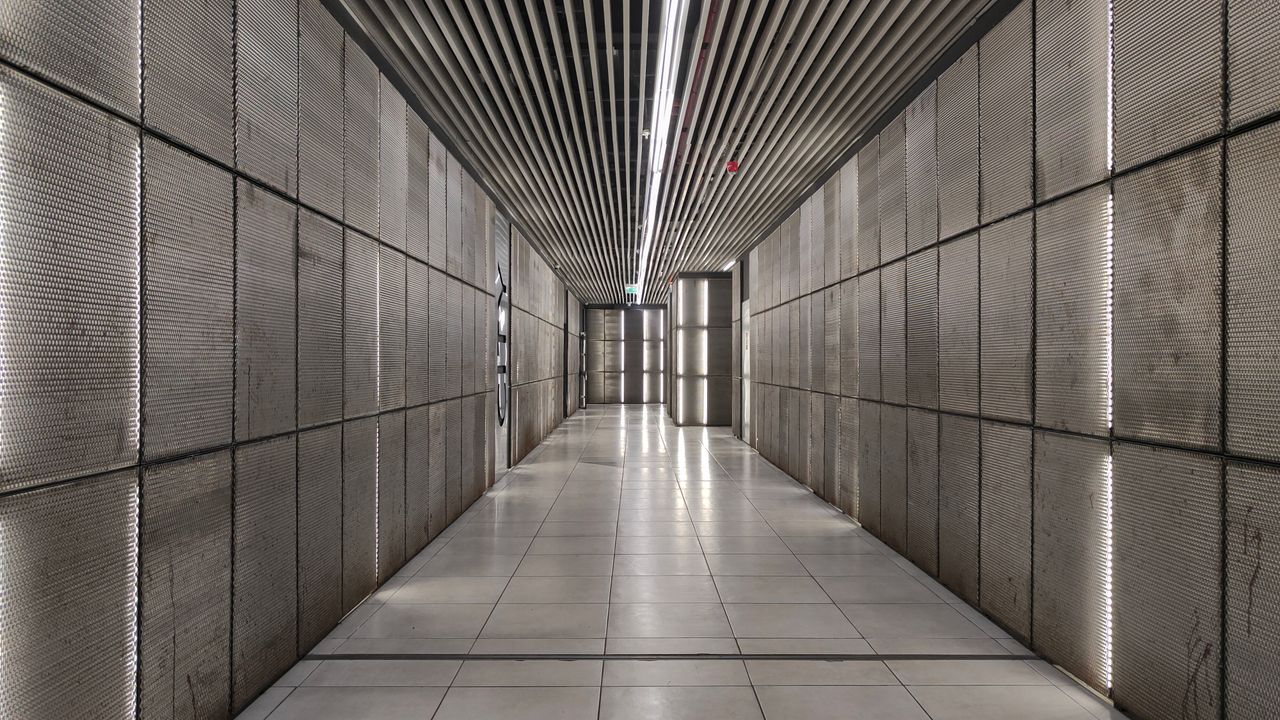 Explore a minimalist, futuristic corridor with textured walls in Tbilisi, Georgia.